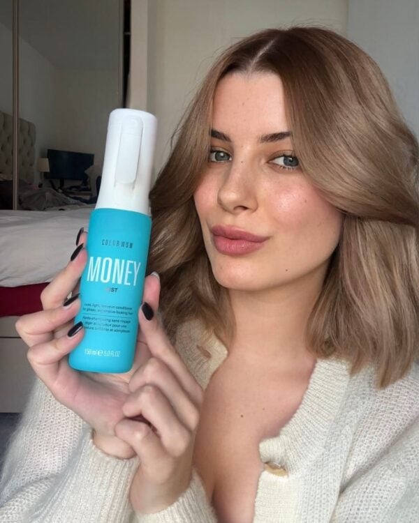 Beauty UGC showing a woman holding a hair styling mousse product during a natural makeup and hair routine