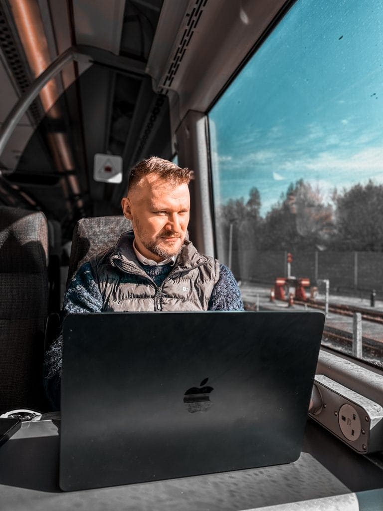 LinkedIn Services. Business consultant working on LinkedIn strategy from a train with a laptop