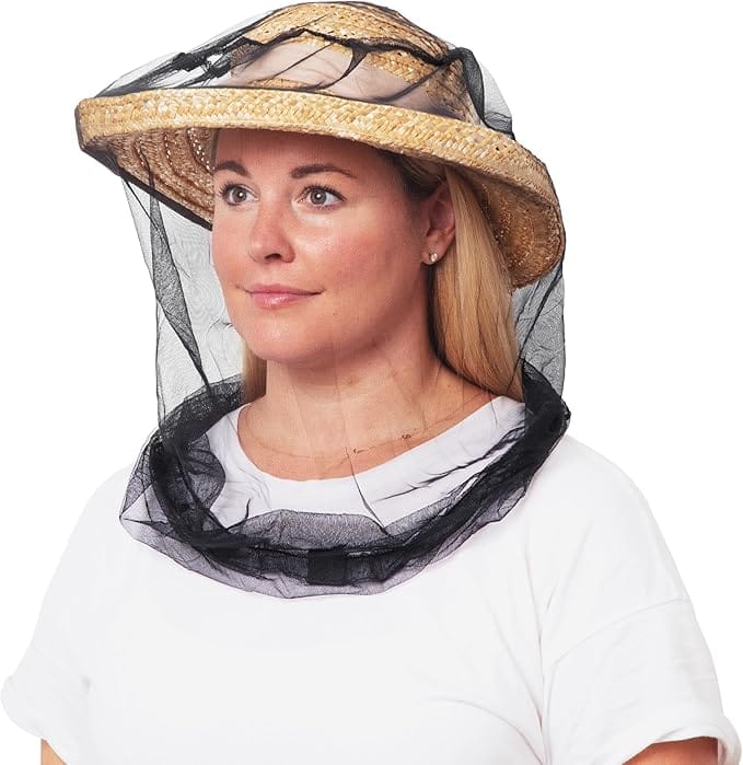 Woman wearing a straw hat with a black mosquito head net draped over her face and neck, providing full insect protection.