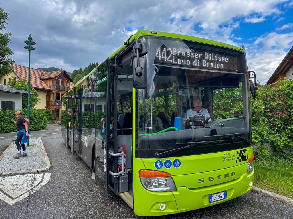 Green public bus marked “442 Pragser Wildsee / Lago di Braies” parked at a stop with passengers nearby.