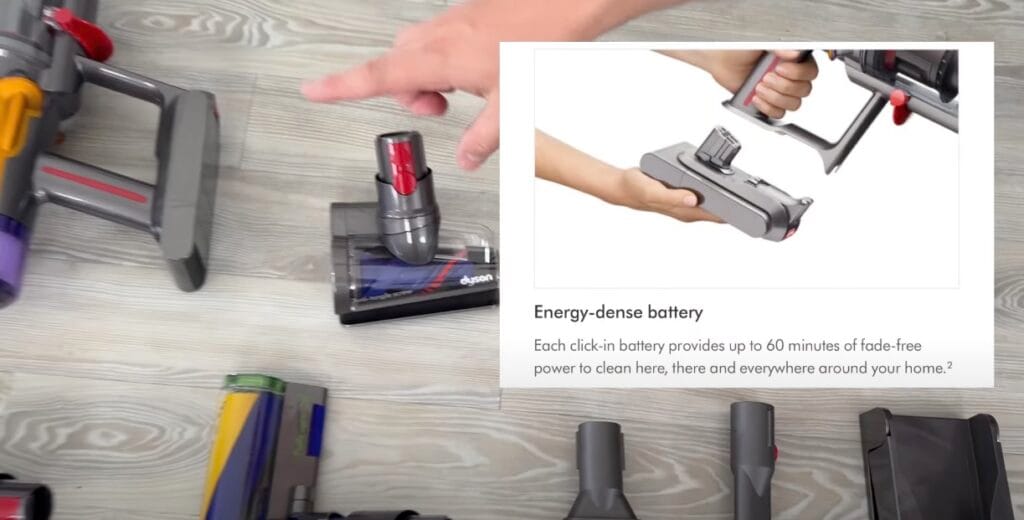Close-up of Dyson cordless vacuum components on the floor with a hand pointing to a battery-powered motorhead, alongside an inset image showing how to click in the removable battery.
