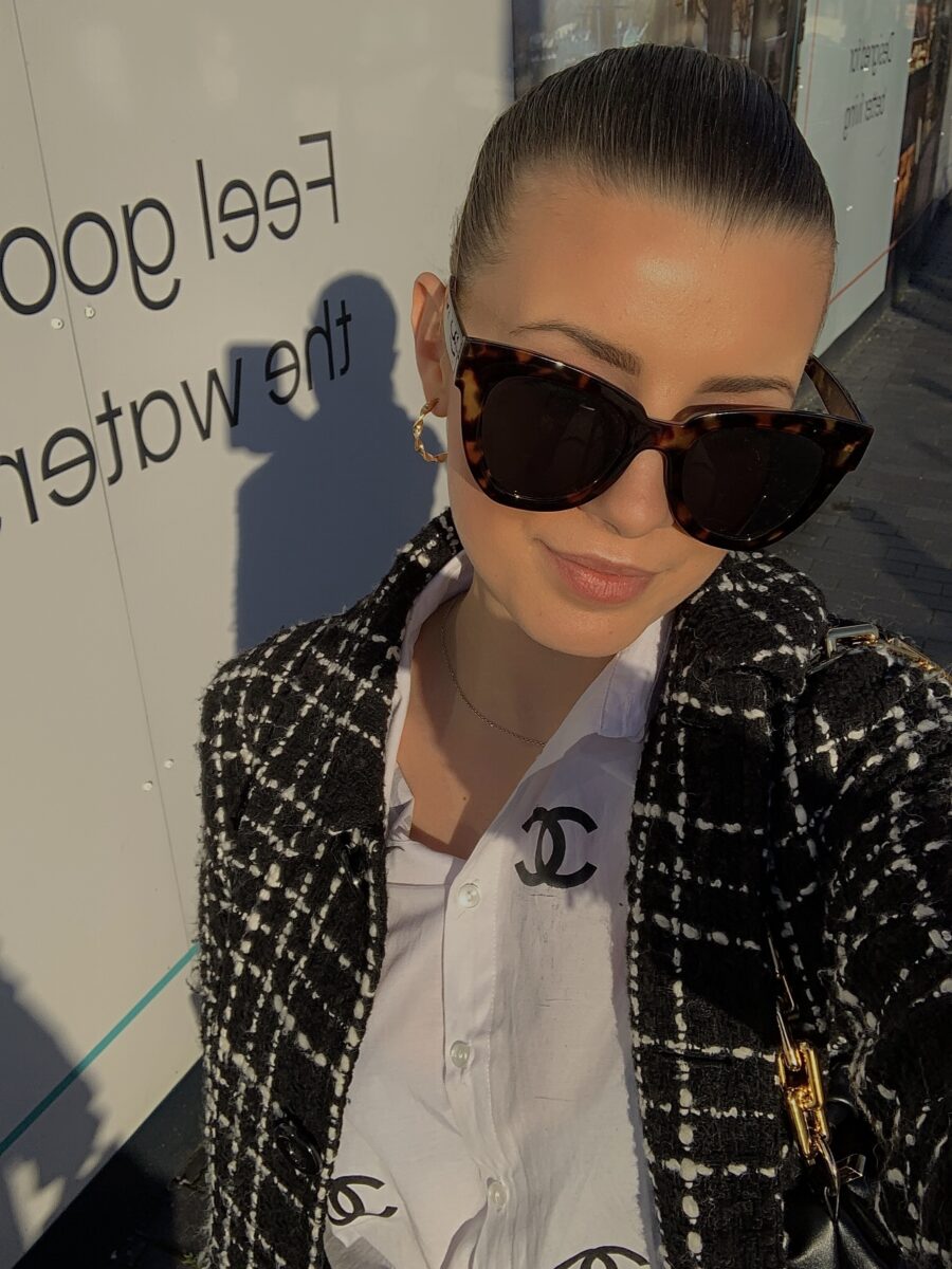 Stylish woman wearing oversized sunglasses and a designer blazer for a lifestyle influencer look.