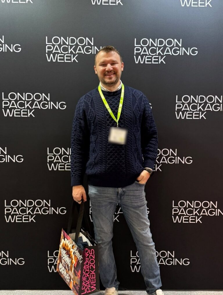 Dragos Nistor at the London Packaging Week 2025 backdrop, in a navy cable knit jumper