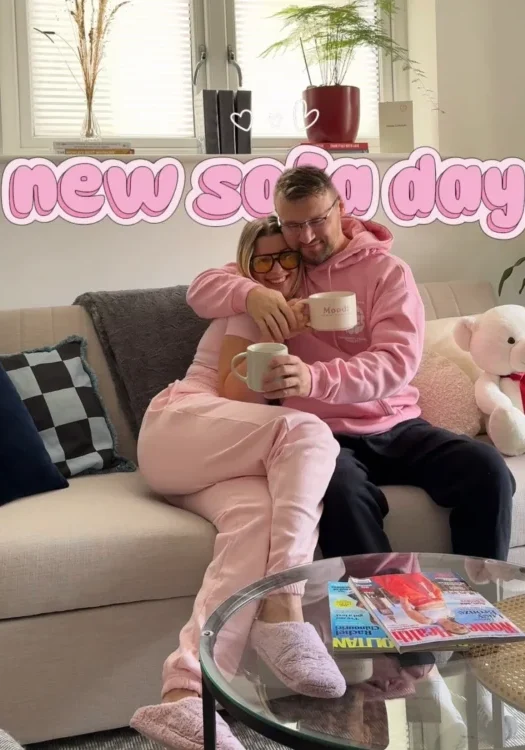 Lifestyle UGC showing a couple relaxing at home on a sofa holding mugs of coffee in a cosy living room setting