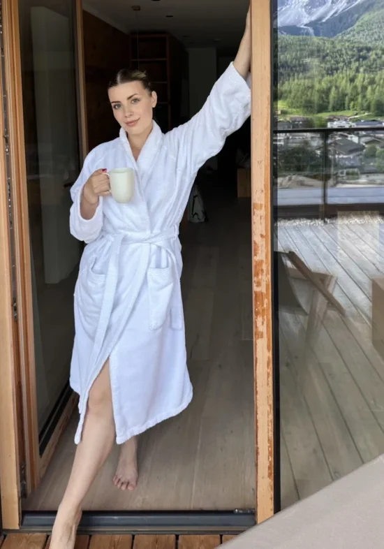 Hospitality UGC showing a relaxed hotel guest enjoying a morning coffee on a balcony with mountain views