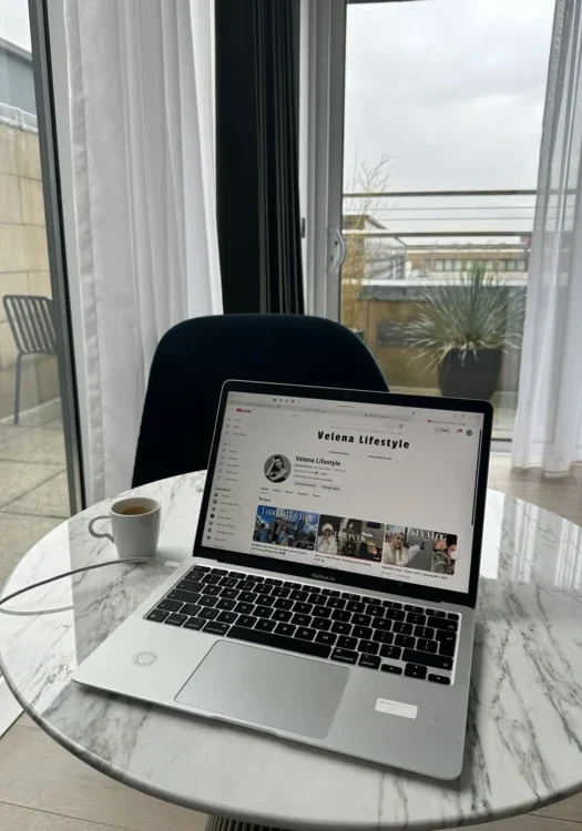 Tech UGC showing a laptop on a marble table displaying a YouTube channel in a modern home workspace